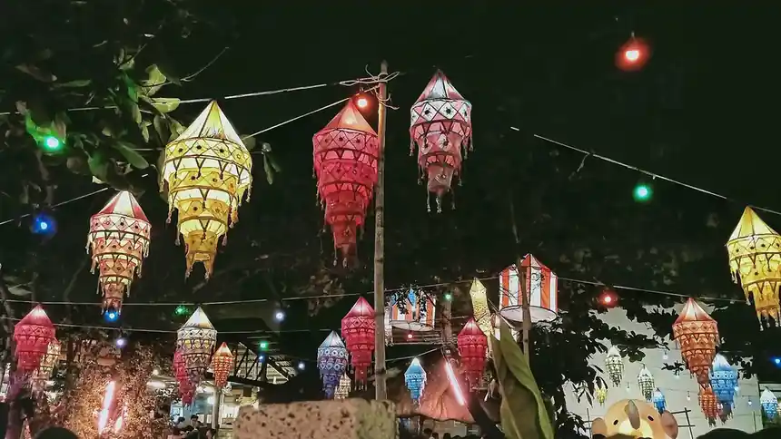 Strings of tiered hanging lanterns in red, amber and white lit up after dark